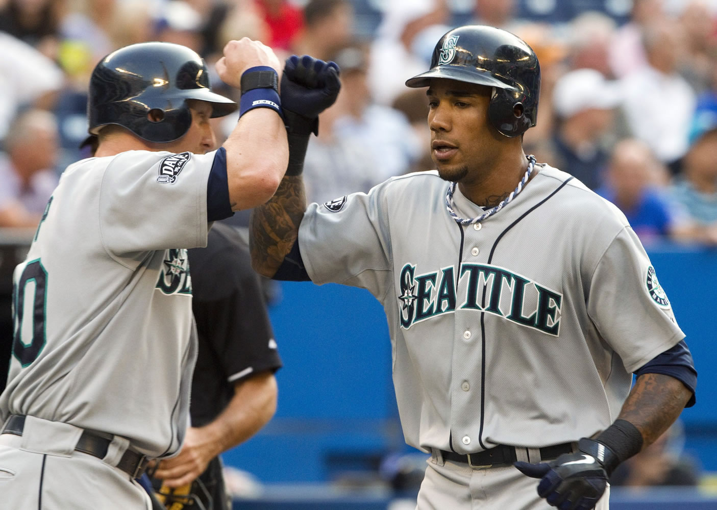 Seattle Mariners' Greg Halman, right, was stabbed to death early Monday in Rotterdam, Netherlands, and his brother was arrested as a suspect, Dutch police said.