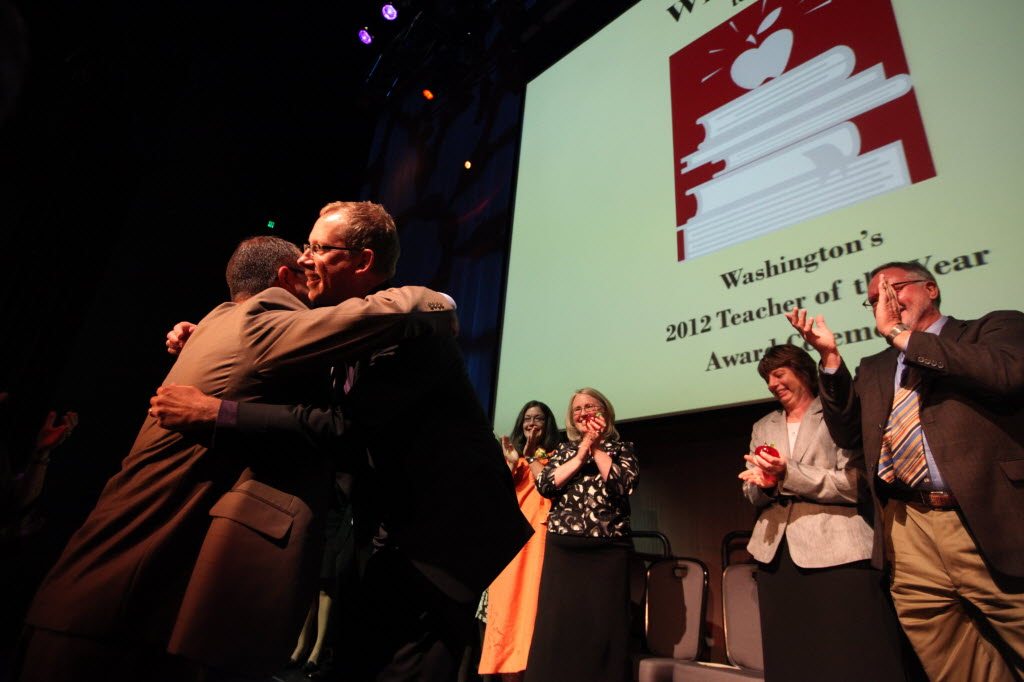 Mark Ray, a librarian at Skyview High School in Vancouver, second left, accepts the Washington State Teacher of the Year award on Monday in Seattle.
