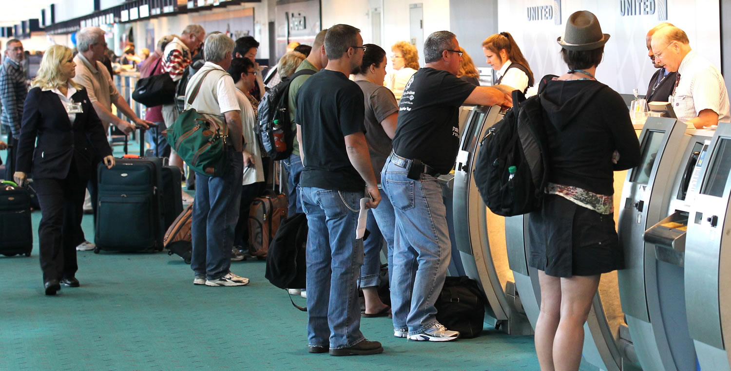 Travelers gather at the ticket counter at Portland International Airport.
