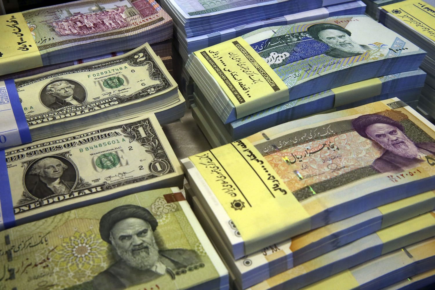 Iranian and U.S. banknotes are on display at a currency exchange shop in downtown Tehran, Iran. Iran said Tuesday that it successfully transferred some of the billions of dollars&#039; worth of frozen overseas assets following the implementation of the nuclear deal with world powers. But ordinary Iranians are still waiting to see how their daily lives will improve and how fast Iranian companies will gain access to financial markets worldwide.