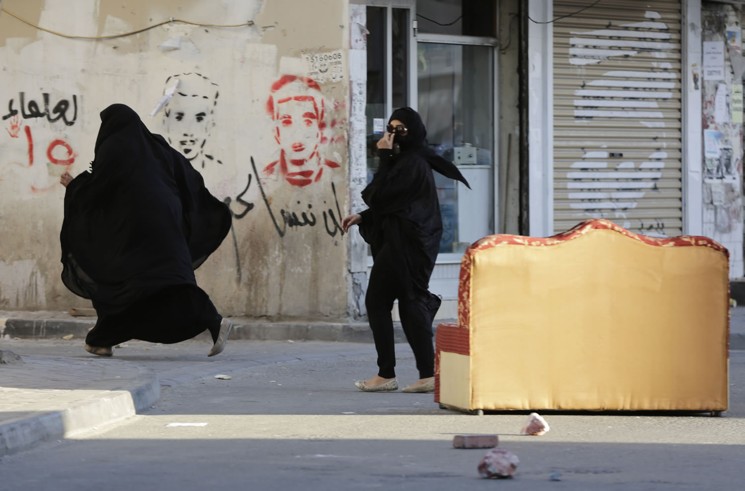 Bahraini women run from approaching riot police who were chasing protesters against Saudi Arabia&#039;s execution of Shiite cleric Sheikh Nimr al-Nimr in Daih, Bahrain, a largely Shiite suburb of the capital Monday. Graffiti on the wall reads, &quot;we will not forget you,&quot; beneath pictures of people killed in previous unrest. Allies of Saudi Arabia, including the monarchy in neighboring Bahrain, began scaling down their diplomatic ties to Iran in the wake of the ransacking of Saudi diplomatic missions in Iran that followed al-Nimr&#039;s execution.