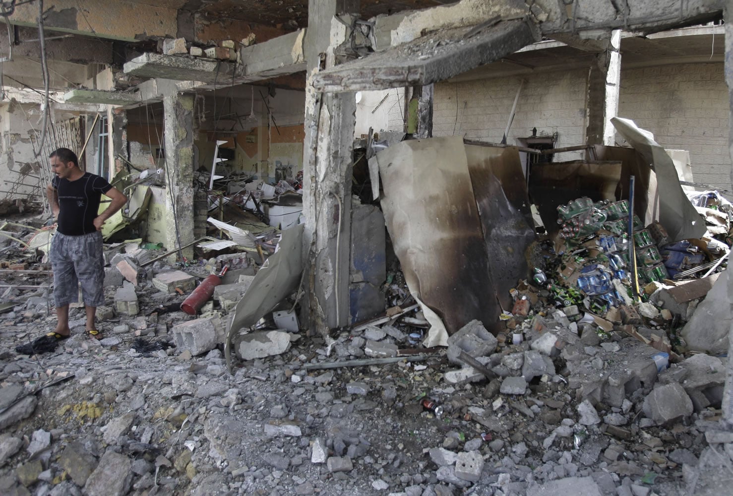 An Iraqi man inspects a destroyed liquor store after a bomb attack Thursday in Baghdad.