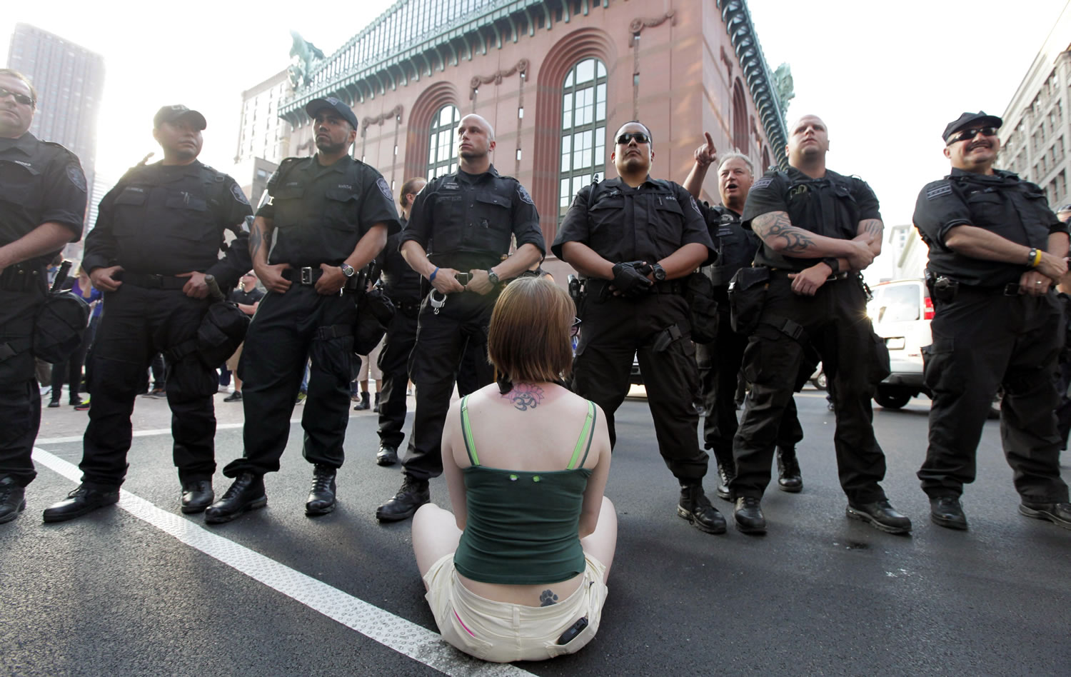 A protester sits in front of Chicago police officers Saturday during a  demonstration on State Street  in downtown Chicago over the two-day NATO summit that begins today.