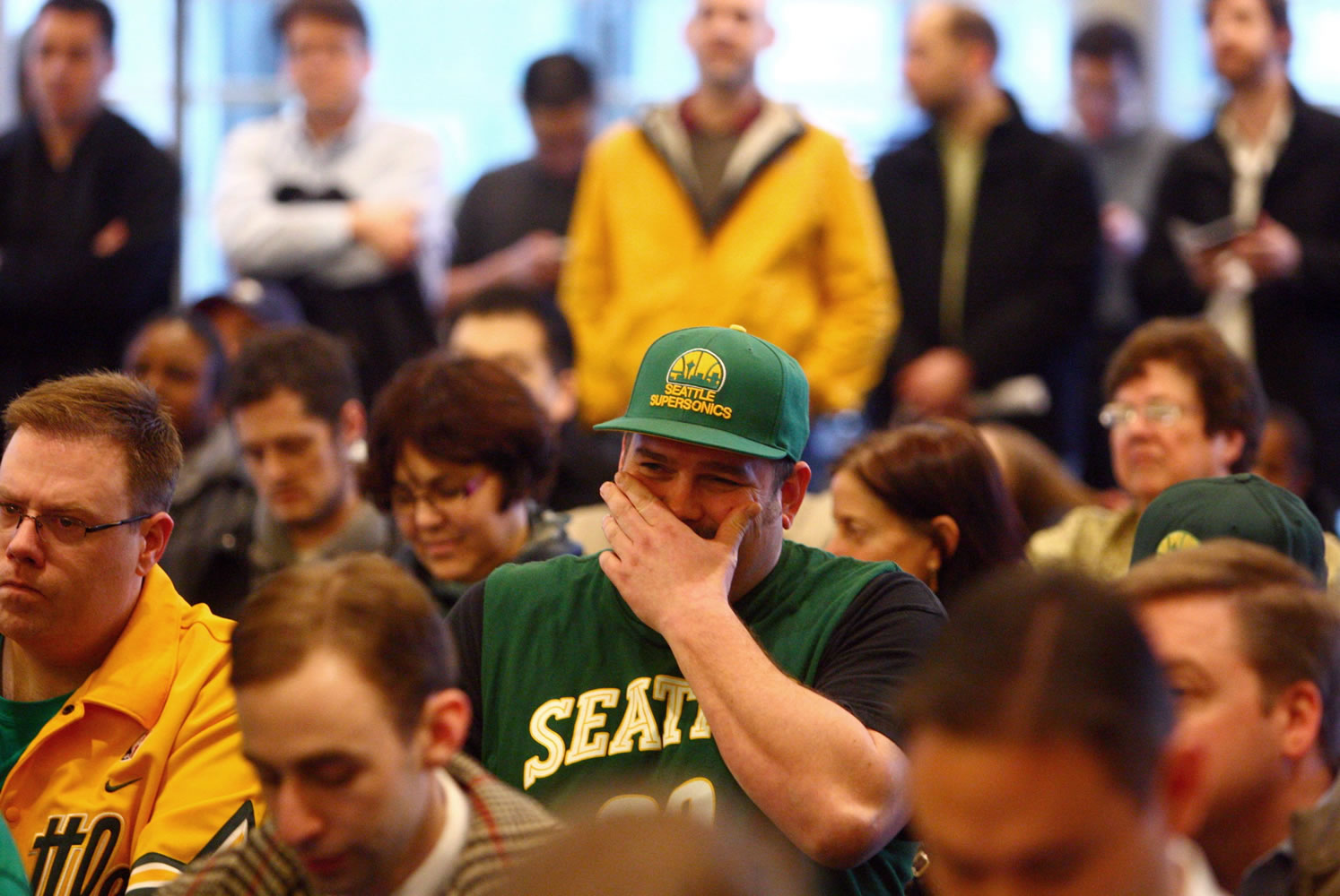 NBA fan Baldwin Poolio, center, reacts to an announcement by Seattle Mayor Mike McGinn and King County executive Dow Constantine about a potential new Seattle NBA and NHL arena on Thursday, Feb.
