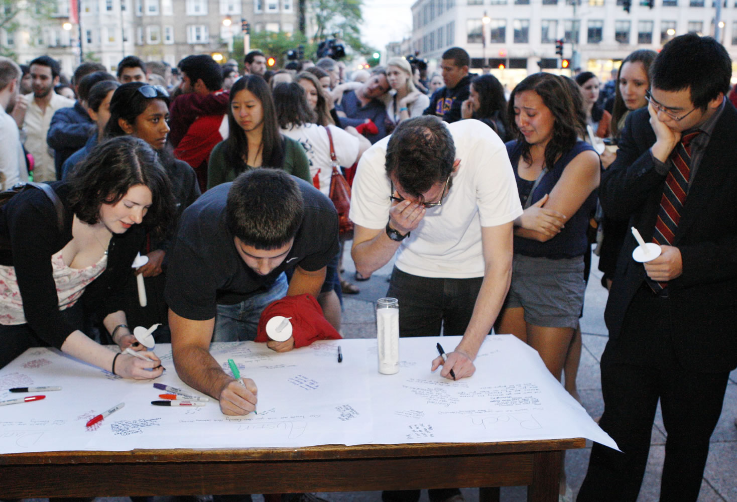 Boston University students gather to sign a condolence note prior to a candlelight vigil on Marsh Plaza at Boston University, Saturday, May 12, 2012, in Boston, for three students studying in New Zealand who were killed when their minivan crashed during a weekend trip.  At least five other students were injured in the accident, including one who was in critical condition. Boston University spokesman Colin Riley said those killed in the accident were Daniela Lekhno, 20, of Manalapan, N.J.; Austin Brashears, 21, of Huntington Beach, Calif.; and Roch Jauberty, 21, whose parents live in Paris.