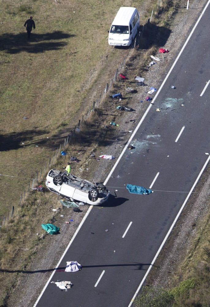 Police and fire crew examine the scene of a minivan crash near Turangi, New Zealand, Saturday, May 12, 2012. Three Boston University students who were studying in New Zealand were killed Saturday when their minivan crashed. At least five other students from the university were injured in the accident, including one who was in critical condition.