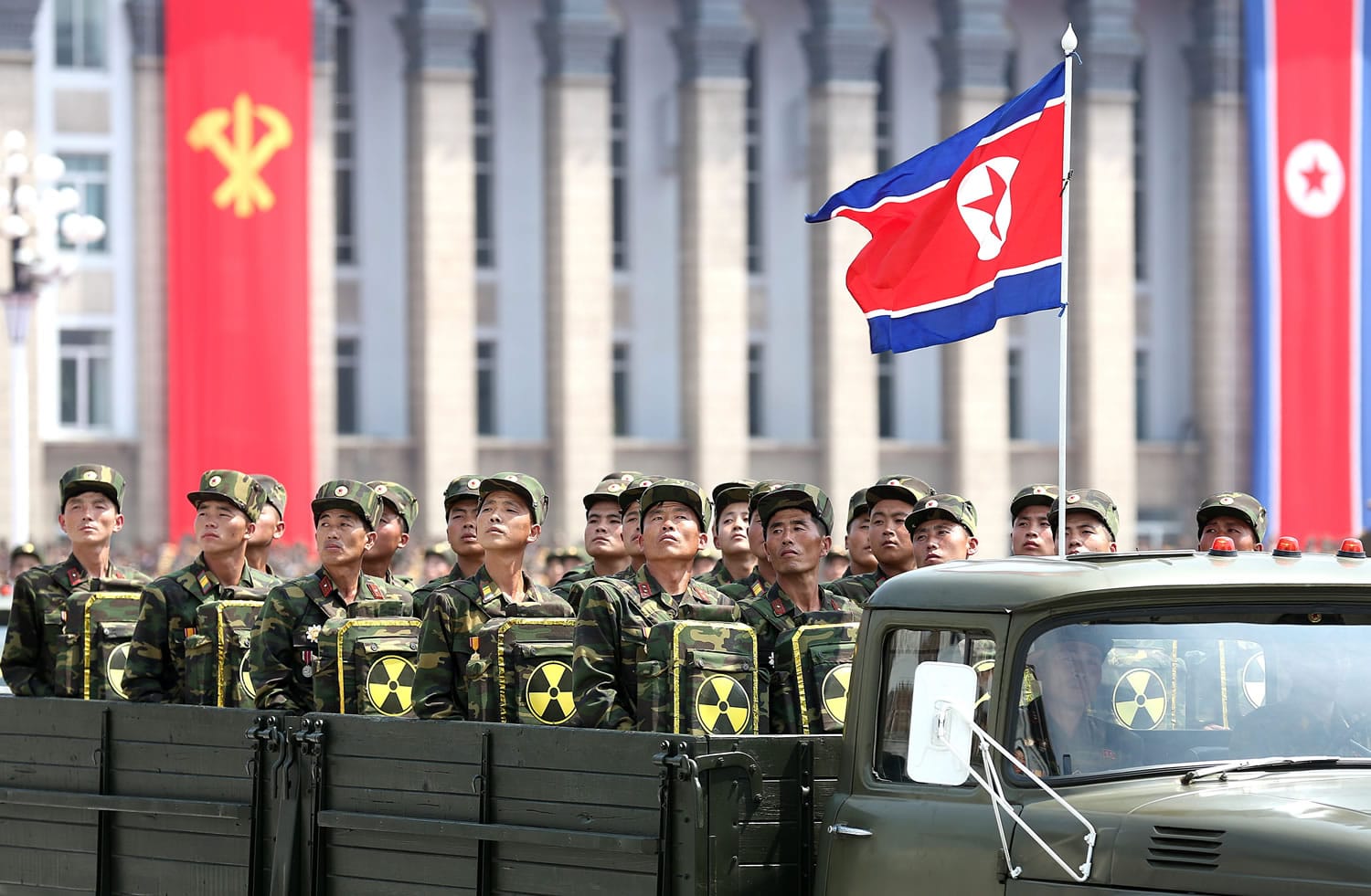 North Korean soldiers turn and look towards leader Kim Jong Un on July 27, 2013 as they carry packs marked with the nuclear symbol during a parade marking the 60th anniversary of the Korean War armistice in Pyongyang, North Korea. It?s a single image released by an enormous propaganda apparatus, showing a note handwritten by a dictator. And it contains a telling clue to the mindset behind what has become the biggest story in Asia: North Korea?s surprise and disputed claim to have tested its first hydrogen bomb.