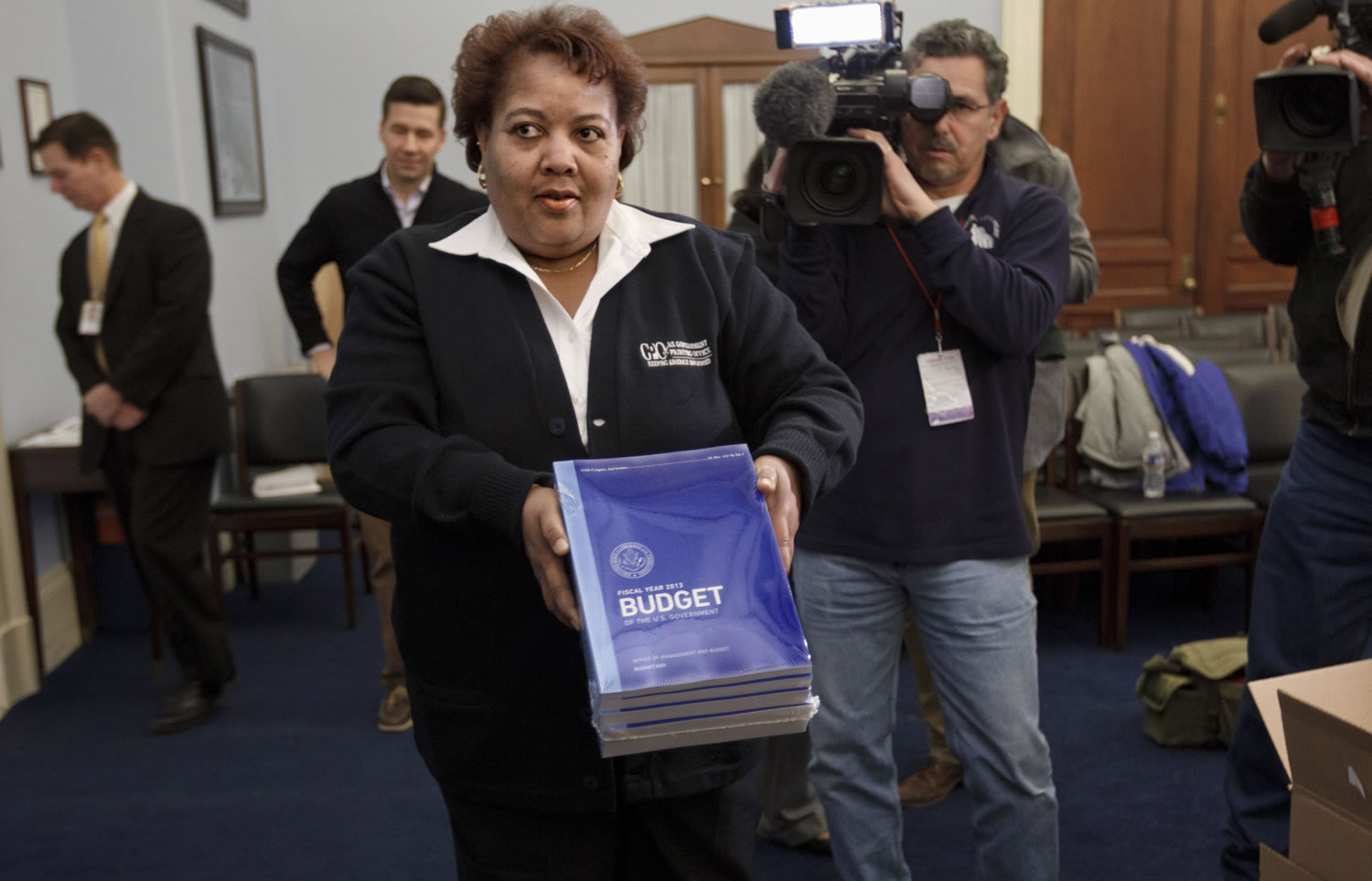 Patricia Gillaird of the Government Printing Office delivers copies of President Barack Obama's fiscal 2013 federal budget Monday to the House Budget Committee, on Capitol Hill in Washington.
