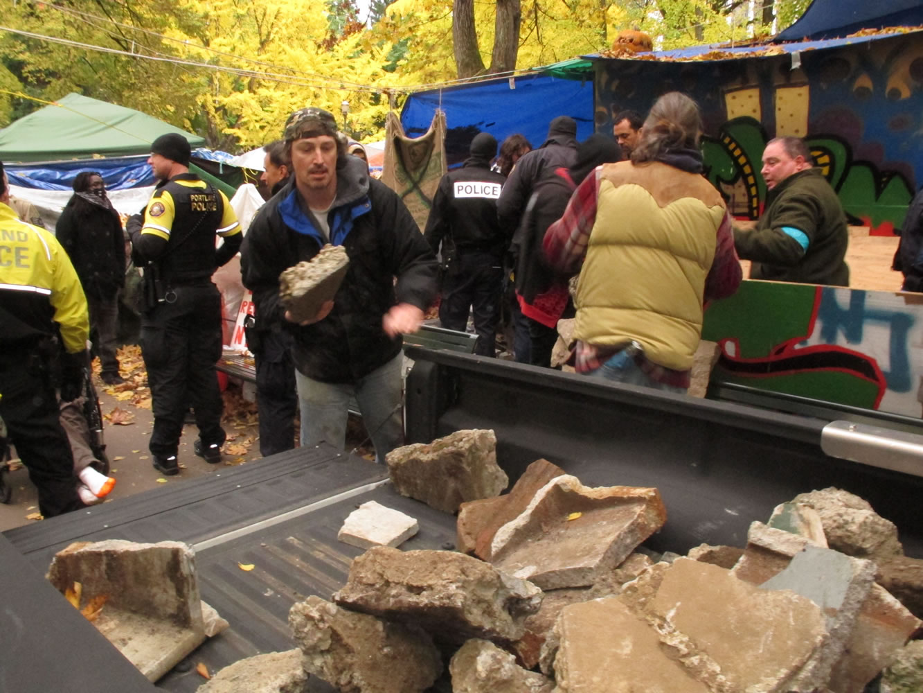 City workers and police seize pieces of concrete that, according to police, may have been brought into the Occupy Portland camp for use as weapons against police in Portland on Friday.