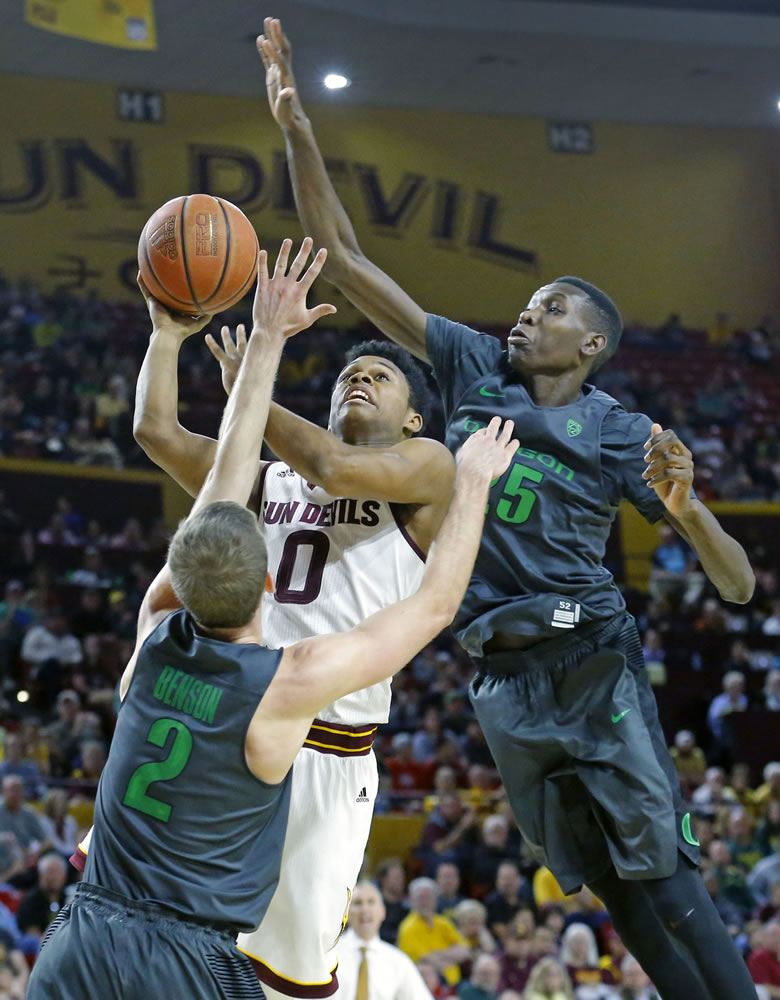 Arizona State Sun Devils guard Tra Holder (0) shoots between Oregon Ducks guard Casey Benson (2) and forward Chris Boucher (25) during the second half of their NCAA basketball game Sunday, Jan. 31, 2016 in Tempe, Ariz.
