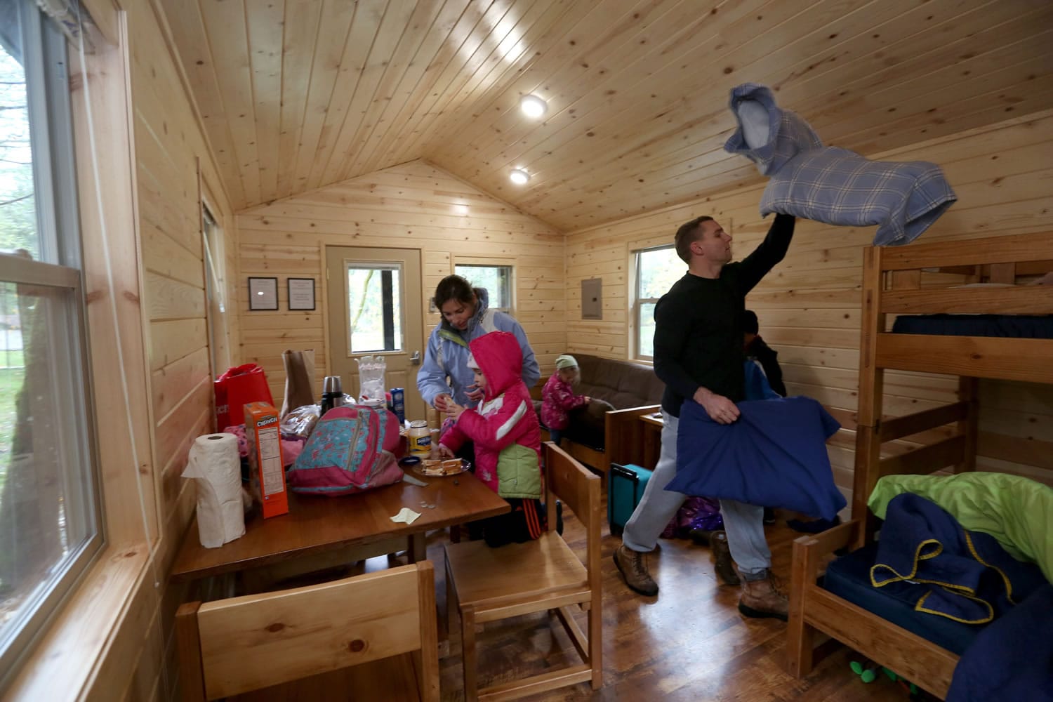 The Thompson family of Tacoma, mom Julianne, dad David and kids Simon, 8; Cecilia, 6; Emilia, 4; and Marilyn, 2, unpack in their cabin at Dash Point State Park in Federal Way in November. &quot;We just wanted to find a place close by and get away from the daily grind,&quot; Julianne Thompson said. (Ellen M.