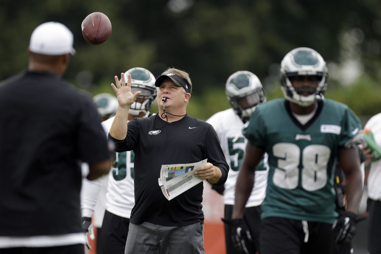 Former Philadelphia Eagles head coach Chip Kelly catches a pass during a joint workout with the New England Patriots at NFL football training camp in Philadelphia, Thursday, Aug.
