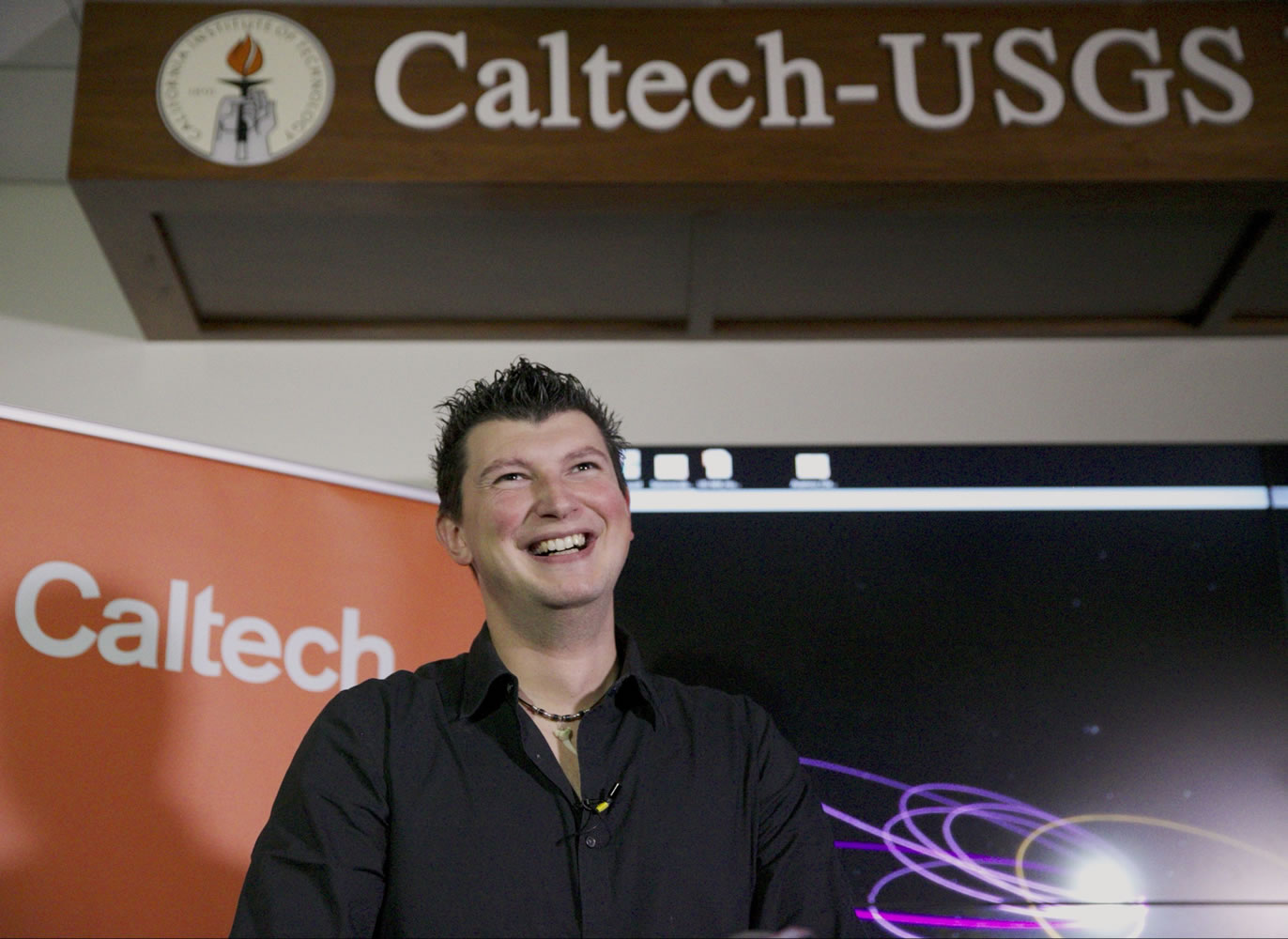 California Institute of Technology Konstantin Batygin, Assistant Professor of Planetary Science smiles as he takes questions about Planet 9 at the CalTech USGS Media center in Pasadena, Calif., on Wednesday, Jan. 20, 2016. Scientists reported Wednesday, they finally have &quot;good evidence&quot; for Planet 9, a true ninth planet on the fringes of our solar system. The gas giant is thought to be almost as big as Neptune and orbiting billions of miles beyond Neptune&#039;s path, distant enough to take 10,000 to 20,000 years to circle the sun. Planet 9, as Batygin and astronomer Mike Brown call it, hasn&#039;t been spotted yet. They base their findings on mathematical and computer modeling, and anticipate its discovery via telescope within five years.