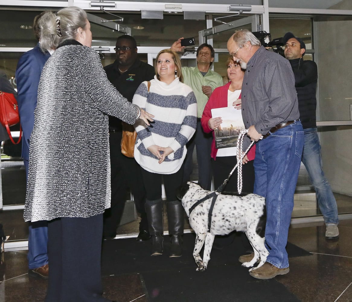 John Robinson, front right, arrives at the Tennessee Lottery headquarters with his wife, Lisa; daughter, Tiffany, center; and family dog Friday, Jan. 15, 2016, in Nashville, Tenn. At left is Rebecca Hargrove, president and CEO of the Tennessee Lottery. The Robinsons claim to have one of the winning tickets in the record $1.6 billion jackpot drawing that took place Wednesday.