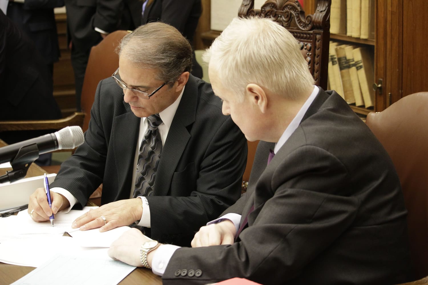 Lt. Gov. Brad Owen signs subpoenas as Secretary of the Senate Hunter Goodman looks on, Tuesday, Jan. 19, 2016, at the Capitol in Olympia, Wash. Legislative subpoenas will be issued for documents related to the erroneous early release of thousands of prisoners in Washington state following a vote by a Senate panel Tuesday night.