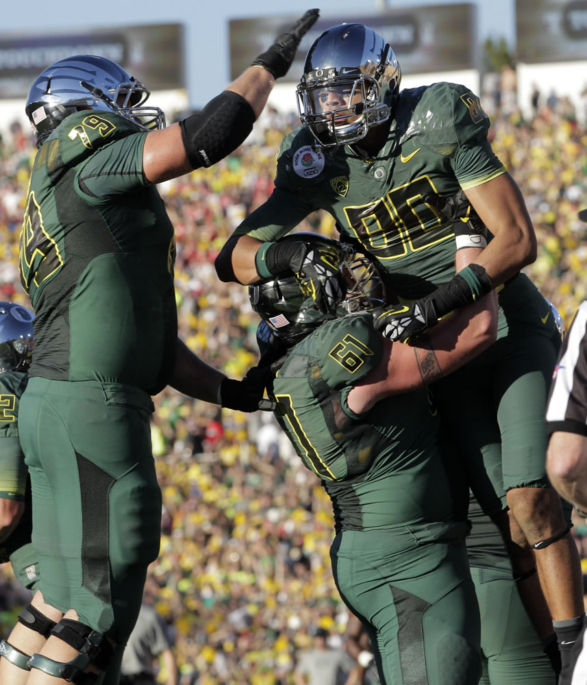 Oregon's Lavasier Tuinei (80), Hockinson High grad Nick Cody (61) and Mark Asper (79) celebrate a touchdown during the first half of the Rose Bowl.
