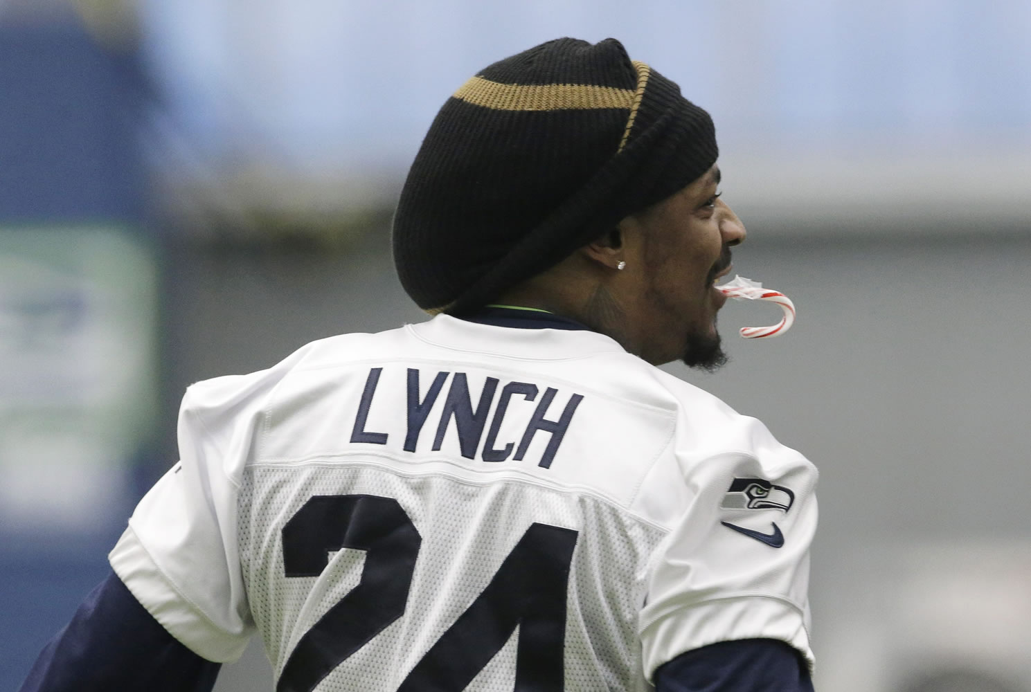 Seattle Seahawks running back Marshawn Lynch holds a candy cane in his mouth as he warms up before NFL football practice, Wednesday, Jan. 6, 2016, in Renton, Wash. Lynch has been recovering since having abdominal surgery last November. (AP Photo/Ted S.