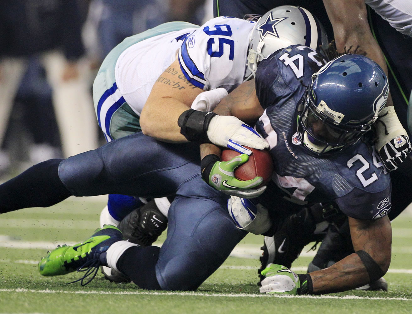 Seattle's Marshawn Lynch is taken down by Dallas' Sean Lissemore during the second half Sunday.