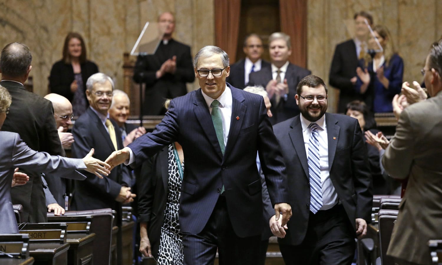 Gov. Jay Inslee shakes hands with legislators after giving his annual State of the State address Tuesday in Olympia. The address came on Day 2 of the 60-day session.