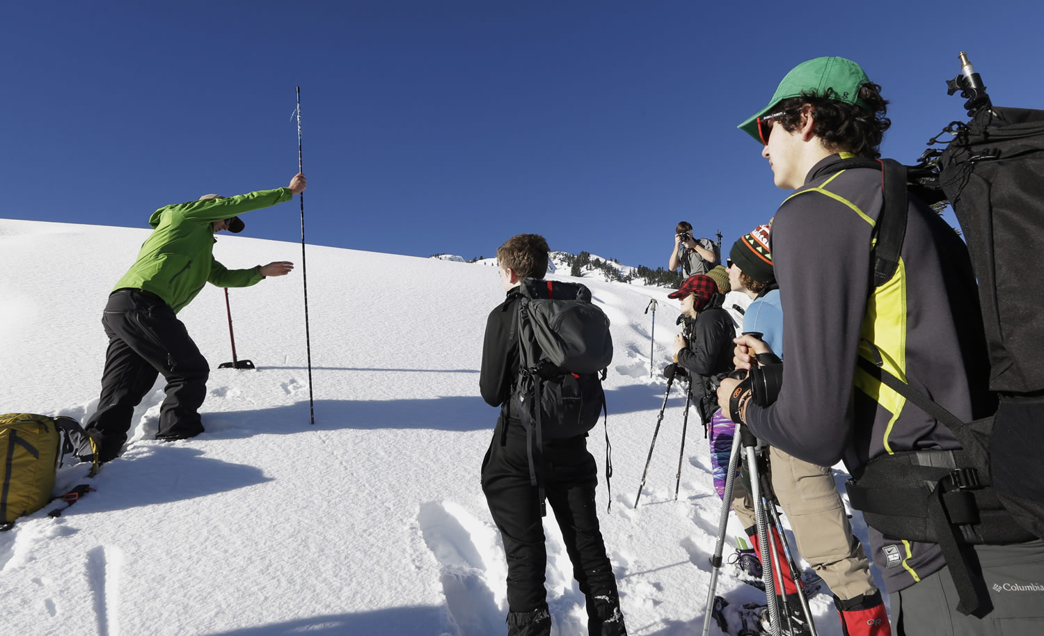 Eric Gullickson, left, instructor with the Northwest Avalanche Center, shows how to use an avalanche probe during an avalanche awareness field trip for teens at Mount Baker.