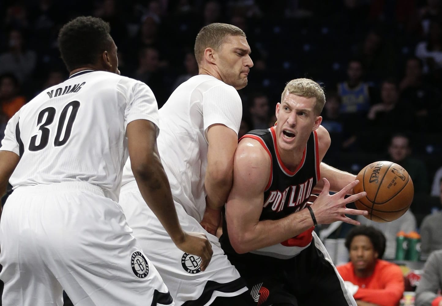 Brooklyn Nets' Brook Lopez, center, defends against Portland Trail Blazers' Mason Plumlee, right, as Nets' Thaddeus Young (30) watches during the first half of an NBA basketball game Friday, Jan. 15, 2016, in New York.