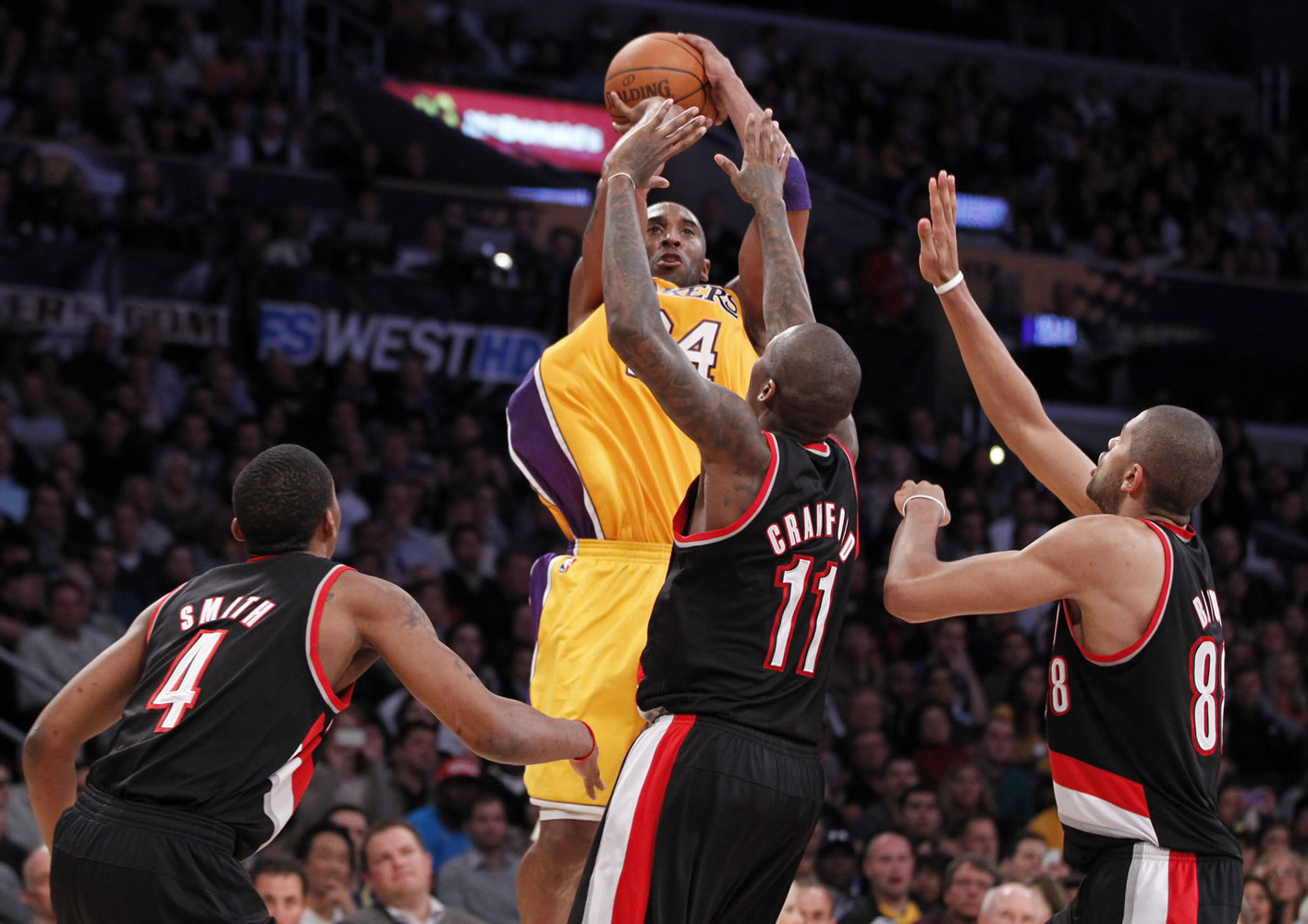 Los Angeles Lakers' Kobe Bryant shoots over Portland Trail Blazers', from left to right, Nolan Smith, Jamal Crawford, and Nicolas Batum during the second half Friday.