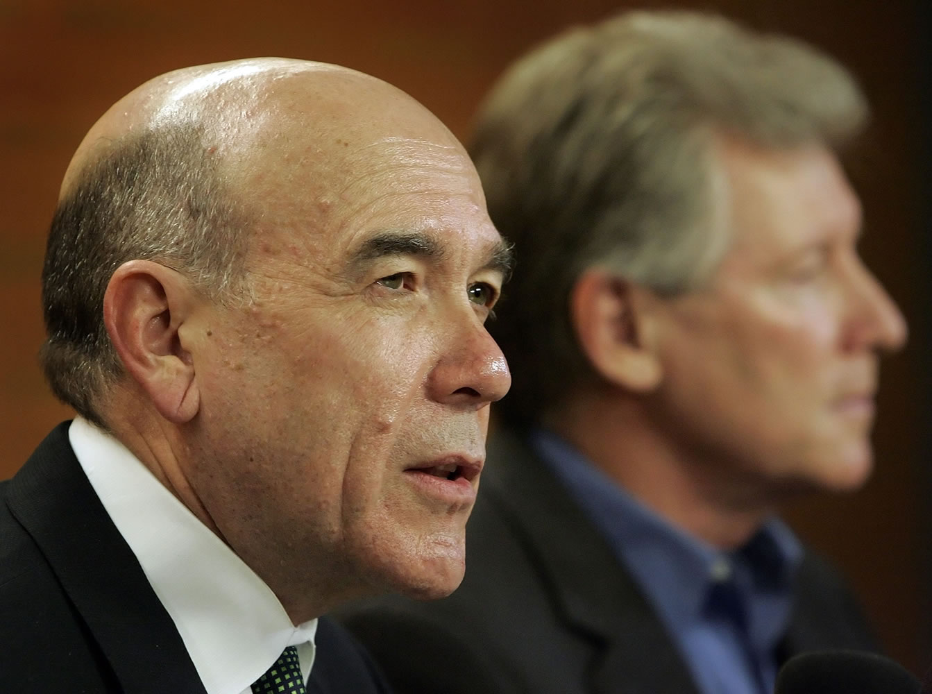 University of Oregon President Richard Lariviere, left, discusses the $2.3 golden parachute for former athletic director Mike Bellotti, right, during a news conference April 6, 2010 in Eugene, Ore.