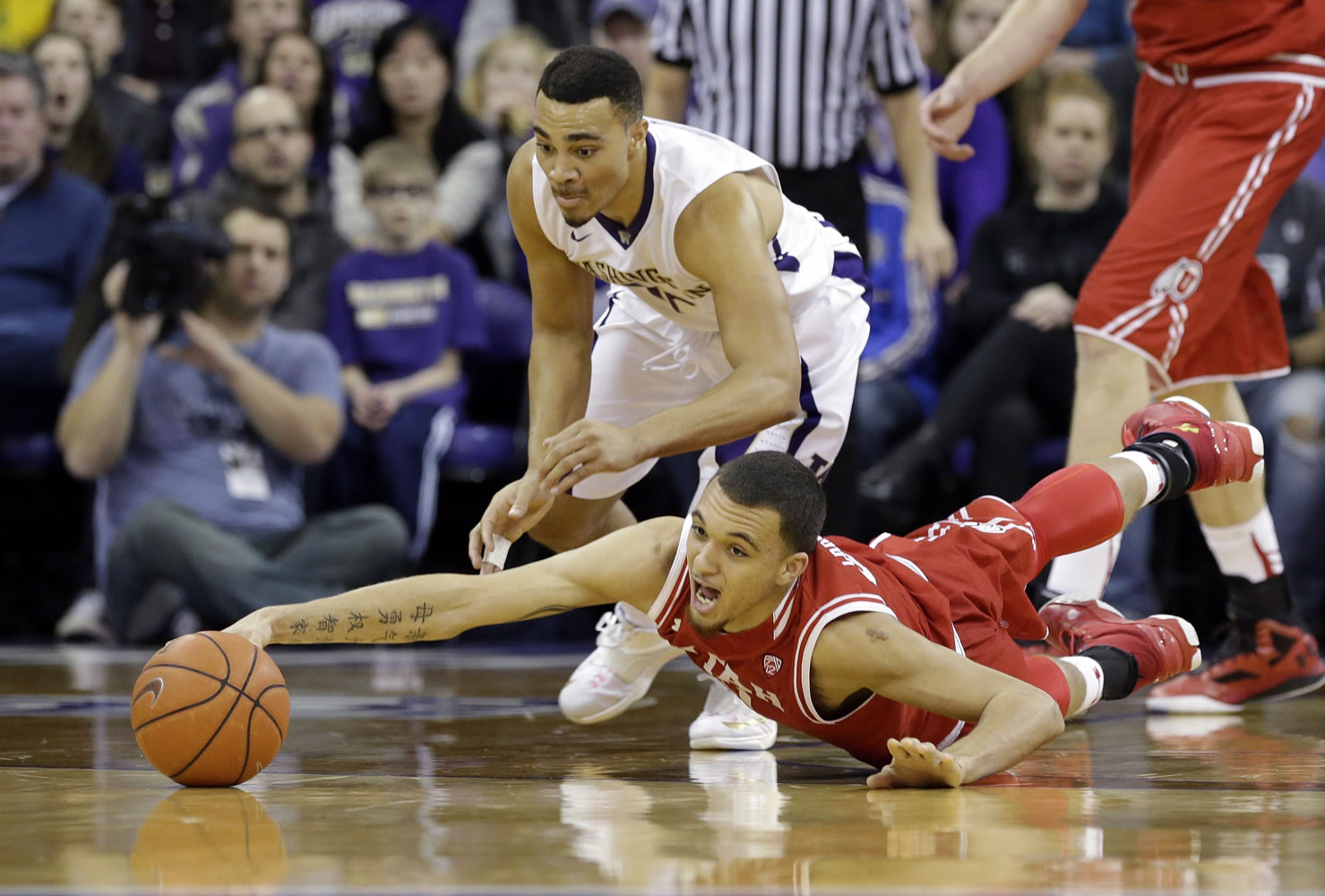 Utah&#039;s Brekkott Chapman, right, dives for a loose ball as Washington&#039;s Andrew Andrews closes in on the play.