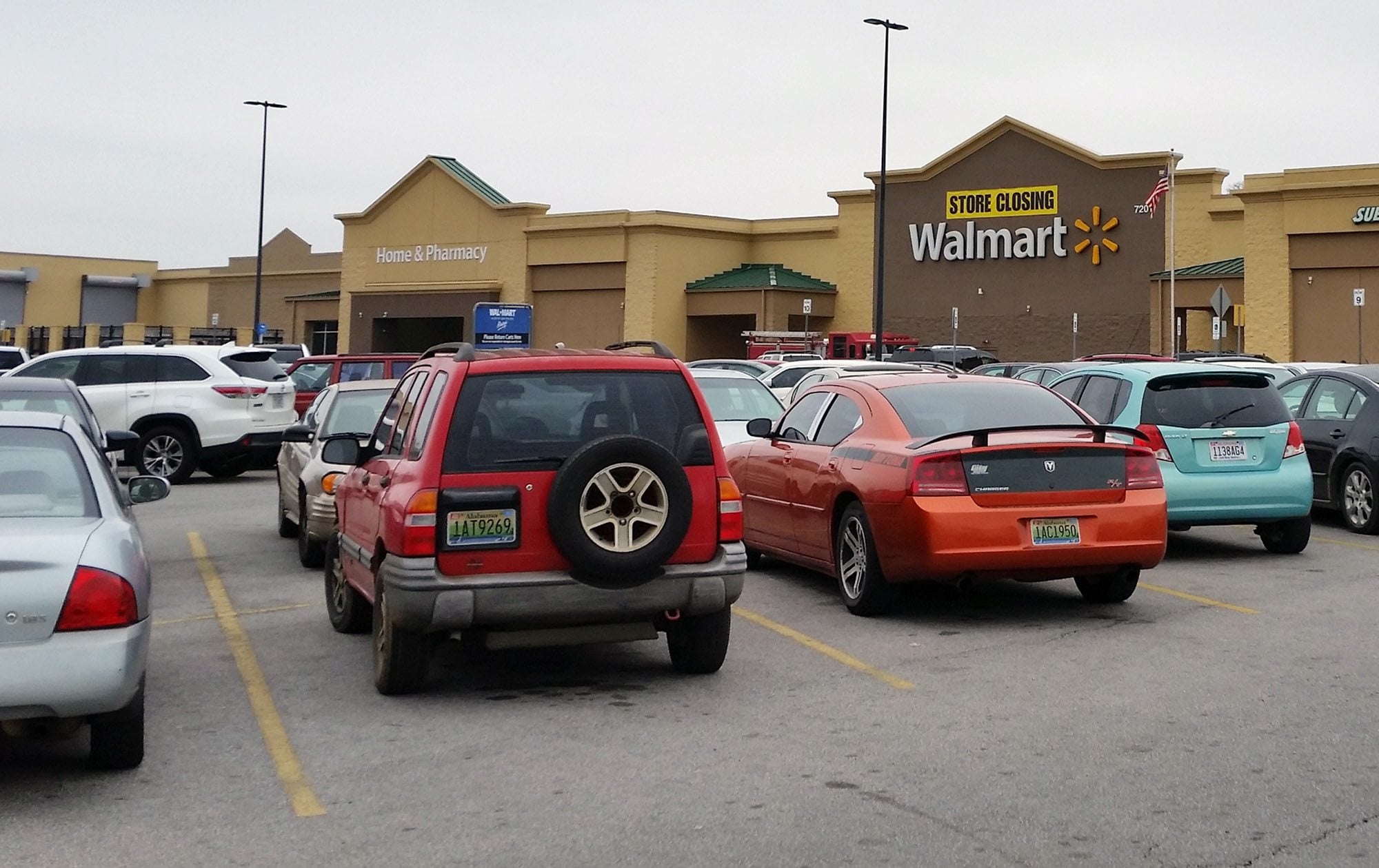 Cars fill the parking lot of a Wal-Mart store in Fairfield, Ala., as it prepares to shut down. Stores slated to shut down will leave residents in parts of Fairfield, Ala.; Coal Hill, Ark.; and Wichita, Kan., without a supermarket.