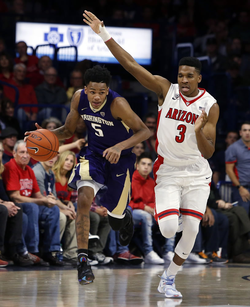 Washington guard Dejounte Murray (5) carries the ball past Arizona guard Justin Simon during the first half of an NCAA college basketball game, Thursday, Jan. 14, 2016, in Tucson, Ariz.