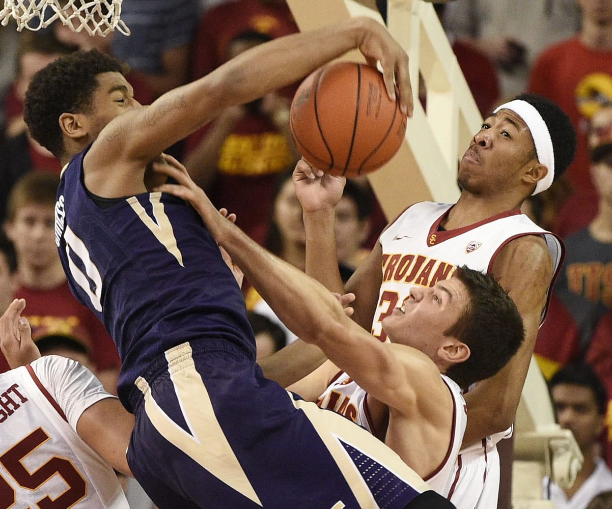 Washington forward Marquese Chriss, left, reaches for a rebound in front of Southern California guard Elijah Stewart, right, and Nikola Jovanovic, bottom during the second half of an NCAA college basketball game in Los Angeles, Saturday, Jan. 30, 2016. Southern California won 98-88.