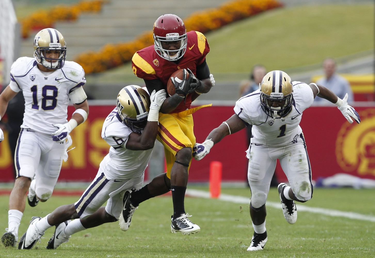 Southern California's Marquise Lee is tackled by Washington's Desmond Trufant after a 14-yard gain in the second half Saturday.