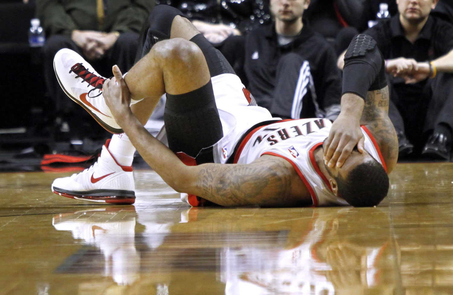 Portland Trail Blazers forward LaMarcus Aldridge holds his ankle after landing on another players' foot during the first quarter of their NBA basketball game against the Washington Wizards in Portland Tuesday.