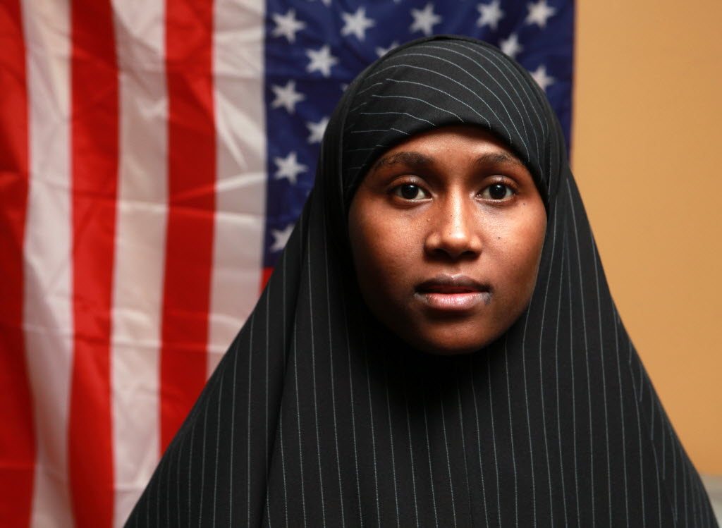 Zainab Aweis, 20, a Somali Muslim poses in front of an American flag in Seattle.