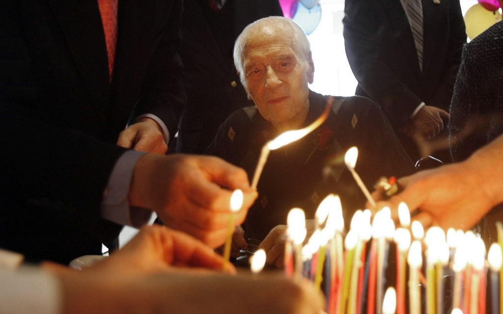 Former Washington Gov. Al Rosellini watches one of his successors, Gary Locke, left, and others light 100 candles on his cake in January 2010. Rosellini died Oct.