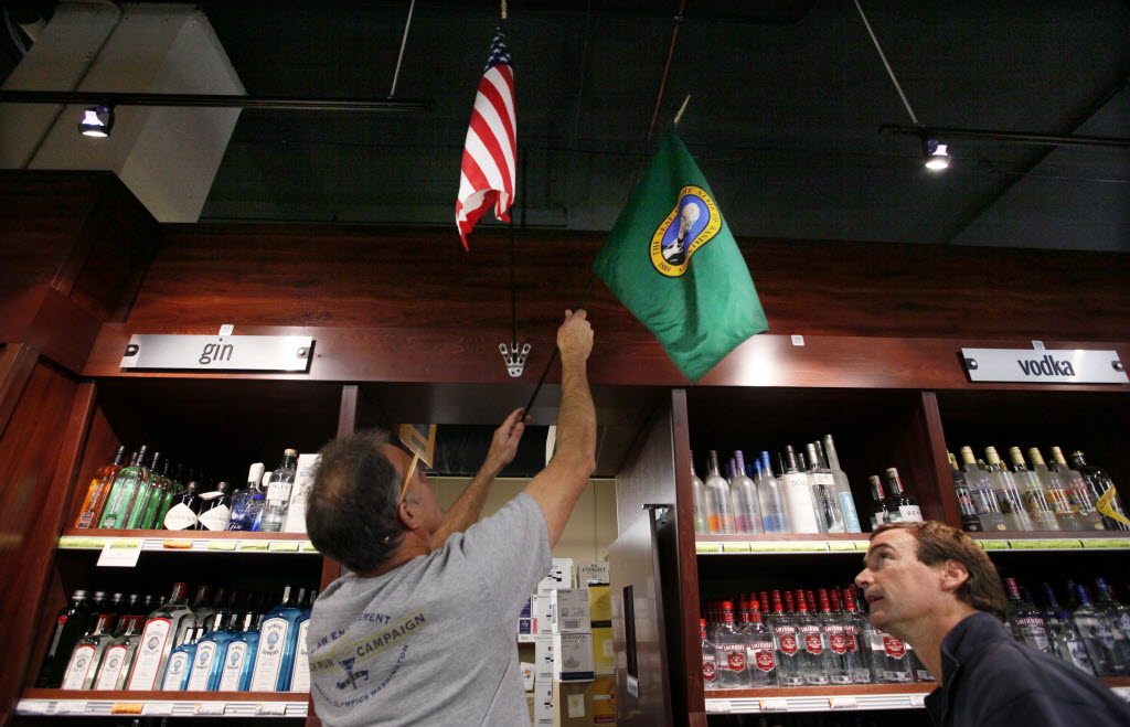 Liquor Control Board carpenters John Stomieroski, left, and Mark Terhune install state and U.S. flags Oct. 31 at a new state liquor store in the West Seattle neighborhood of Seattle.