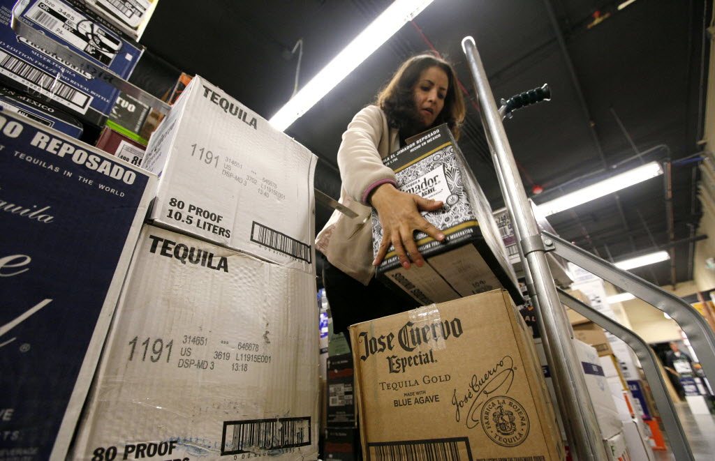 Liquor Control Board clerk Lidia Giusti moves boxes of tequila Oct. 31 at a new state liquor store in the West Seattle neighborhood of Seattle.