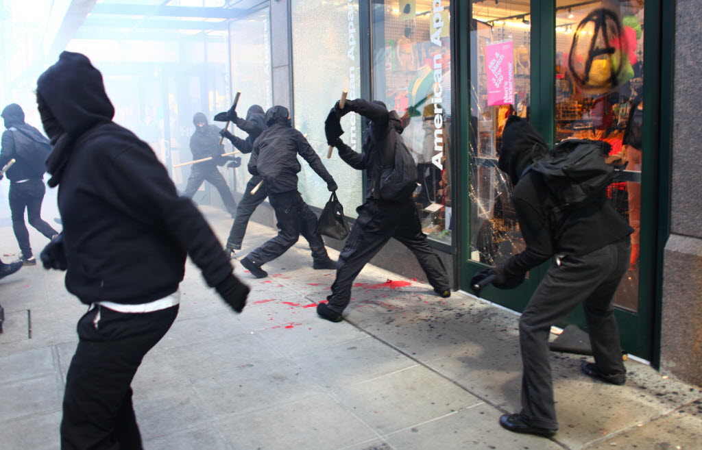 Protesters break windows at downtown businesses including American Apparel and NikeTown during a May Day rally on Tuesday in Seattle.