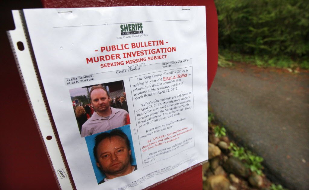A sign warning of murder suspect Peter Alex Keller is seen Friday at a trailhead several miles from where a gun-toting survivalist is suspected of killing his wife and daughter several days earlier in North Bend.