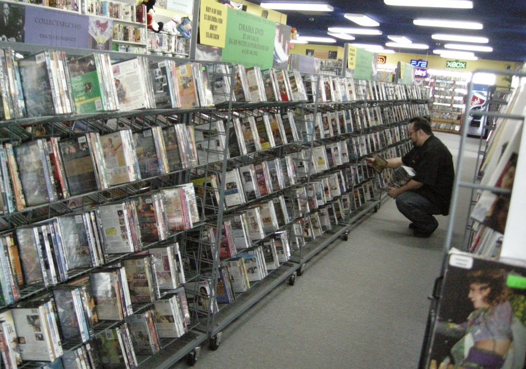 Dustin Chipchase, manager at Movie Movers' Hazel Dell location, stocks the shelves.