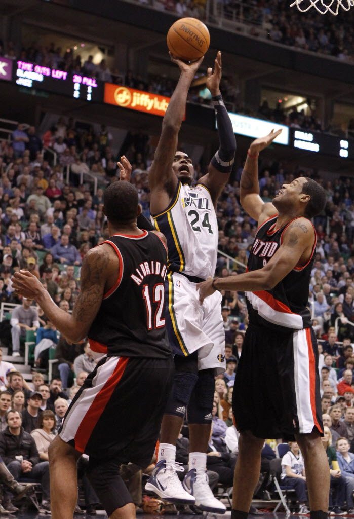 Utah Jazz forward Paul Millsap (24) takes a shot between Portland Trail Blazers forward LaMarcus Aldridge (12) and center Marcus Camby (23) during the second half Monday.