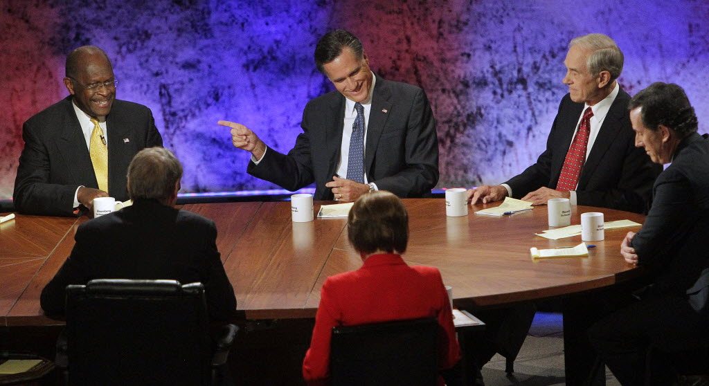 Republican presidential candidate former Massachusetts Gov. Mitt Romney smiles and points his finger at businessman Herman Cain during a Republican presidential debate at Dartmouth College in Hanover, N.H., Tuesday night. Rep. Ron Paul, R-Texas, center right, and former Pennsylvania Sen.