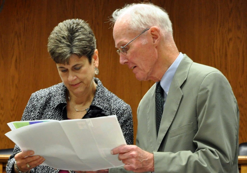 Redistricting Commission Chairwoman Laura Powell and Commissioner Slade Gorton study a proposed map in Olympia on Tuesday.