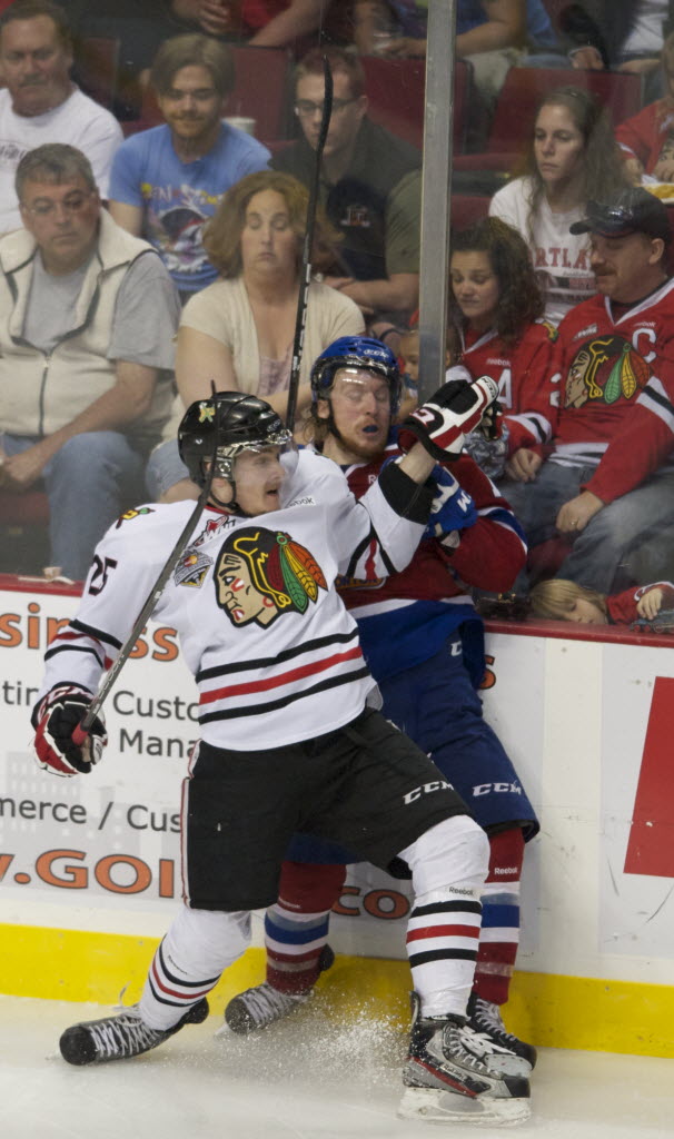 Winterhawks' center Taylor Peters puts Oil Kings' center Jordan Peddle into the boards in the second period of game 6 at the Rose Garden on Saturday.