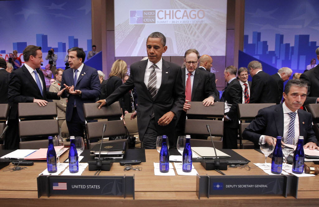 President Barack Obama takes his seat next to NATO Secretary General Anders Fogh Rasmussen, right, at the Partners Meeting at the NATO Summit in Chicago on Monday.