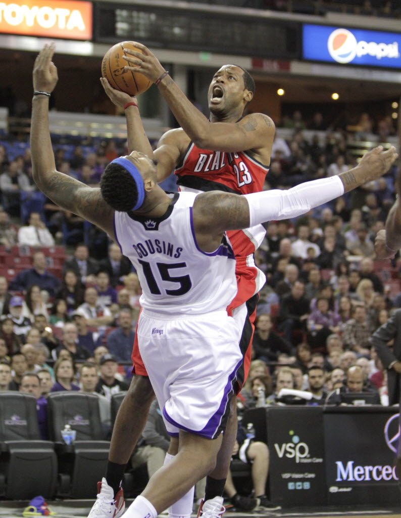 Portland Trail Blazers center Marcus Camby, top, drives to the basket and is fouled by Sacramento Kings center DeMarcus Cousins during the first quarter Thursday.