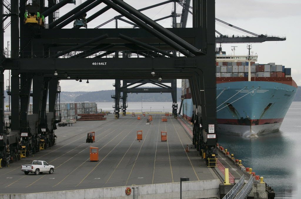 A cargo ship sits docked at the Port of Tacoma as a lone truck crosses normally bustling cargo-handling lanes in May 2008.