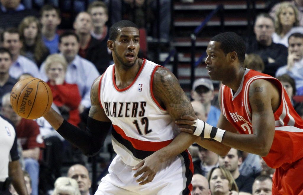 Portland Trail Blazers forward LaMarcus Aldridge, left, looks to pass against Houston Rockets center and former teammate Marcus Camby during the first quarter Monday.