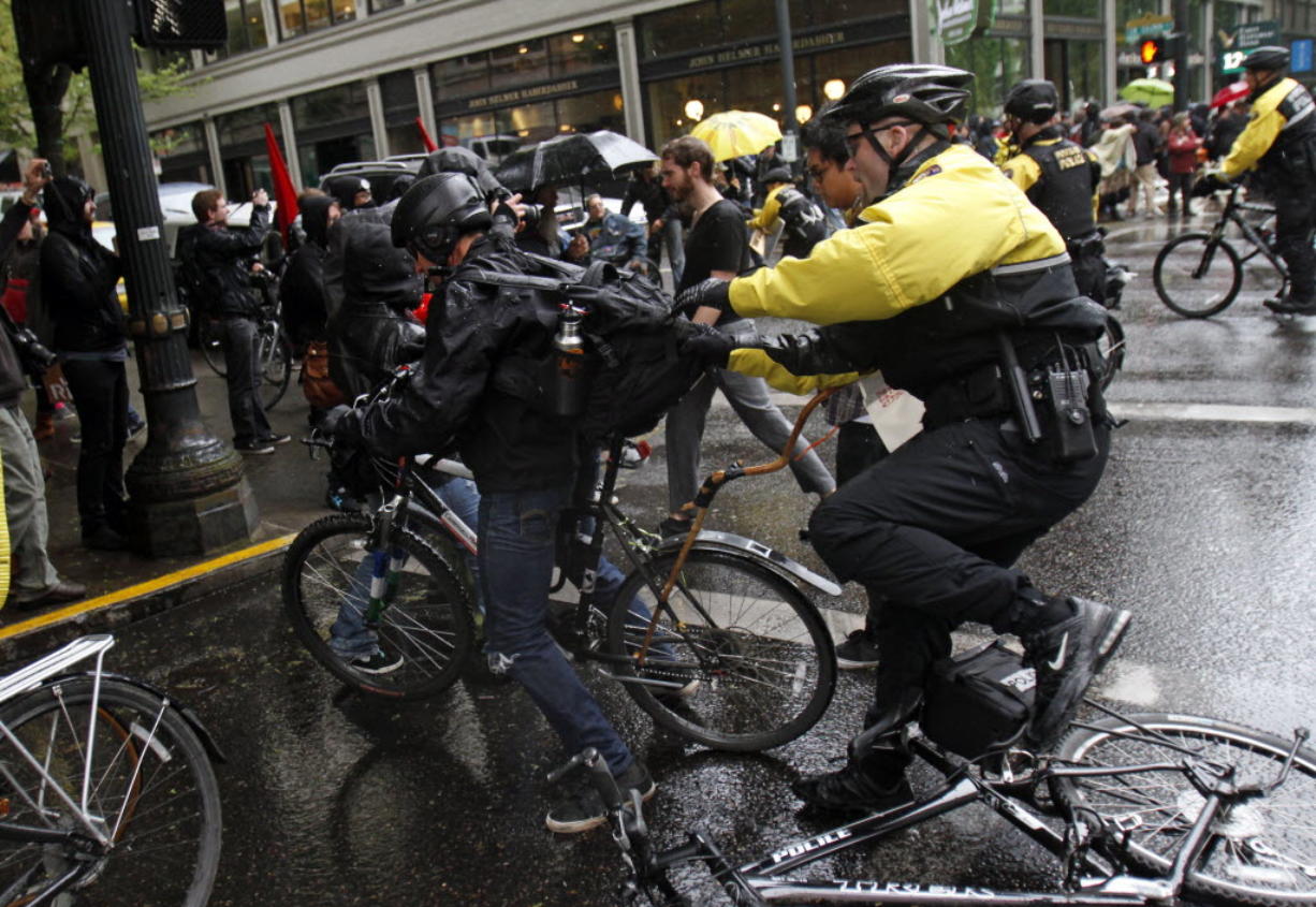 Portland police move in to make arrests during a May Day march and protest in Portland on Tuesday. Hundreds of activists across the U.S.