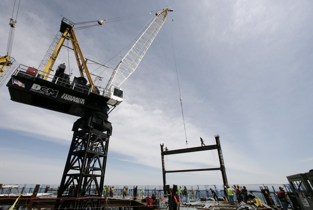 A crane on the top deck of One World Trade Center holds a steel beam between two columns to make the tower New York City's tallest skyscraper on Monday in New York. One World Trade Center is being built to replace the Twin Towers destroyed in the Sept. 11 attacks. It reached just over 1,250 feet on Monday.